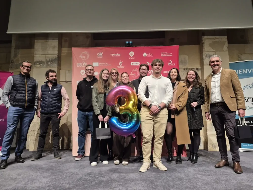Cérémonie de remise des prix du Start-up Challenge Châteauroux 2025. L'équipe classée 3e, composée d'étudiants, pose sur scène avec des ballons du chiffre 3 et des organisateurs de la CCI Indre (The Place by CCI 36)
