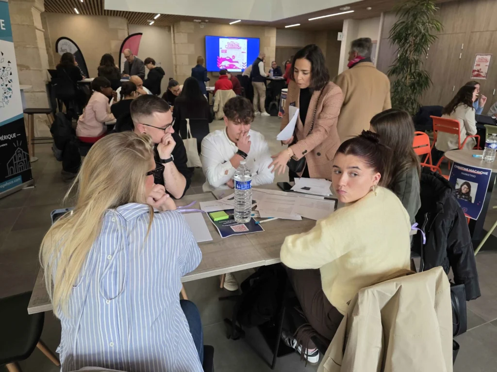 l'équipe travaillant intensément sur leur projet d'innovation lors du Start-up Challenge 2025 à Châteauroux, encadrés par une mentor. Illustration du travail collaboratif et de l'ambiance hackathon.